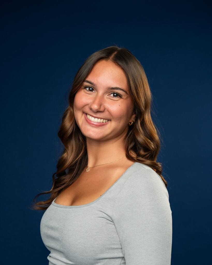 Dancer smiling in clean, fitted outfit for media day headshot