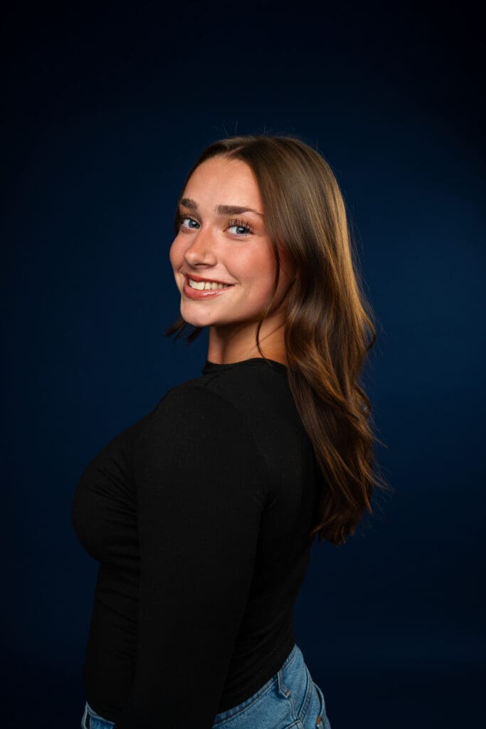 Dancer smiling in clean, fitted outfit for media day headshot