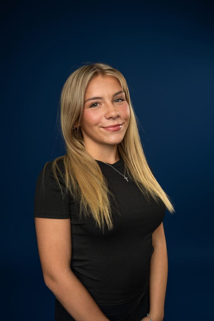 Dancer smiling in clean, fitted outfit for media day headshot
